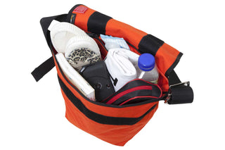 small vintage messenger bag orange with camera, shoes, clothes, water bottle, notebook, and case inside