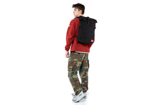 apex backpack black held by male backview